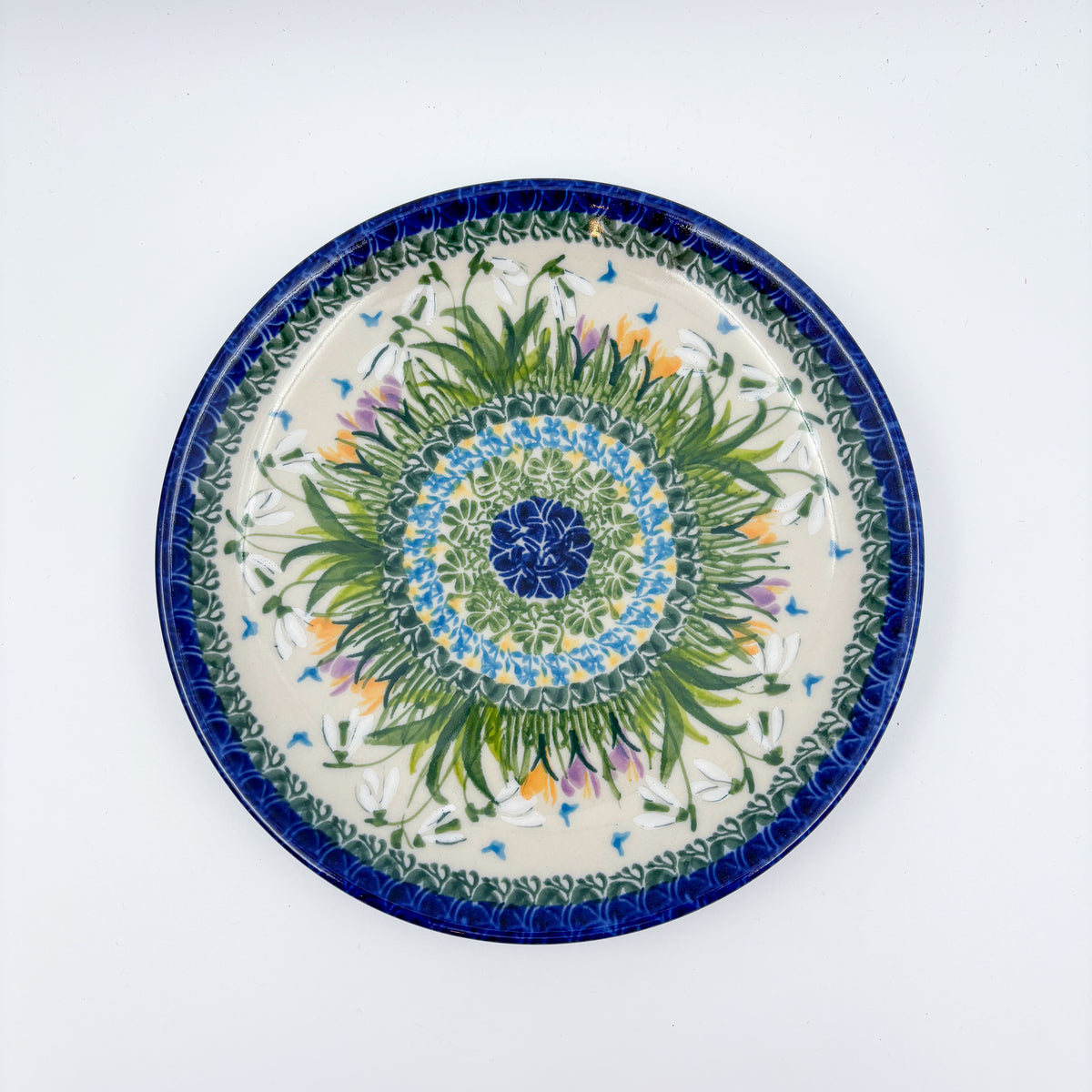 UNIKAT Snowdrop Garden plate, top-down view of green grass burst center with white snowdrops and orange crocuses
