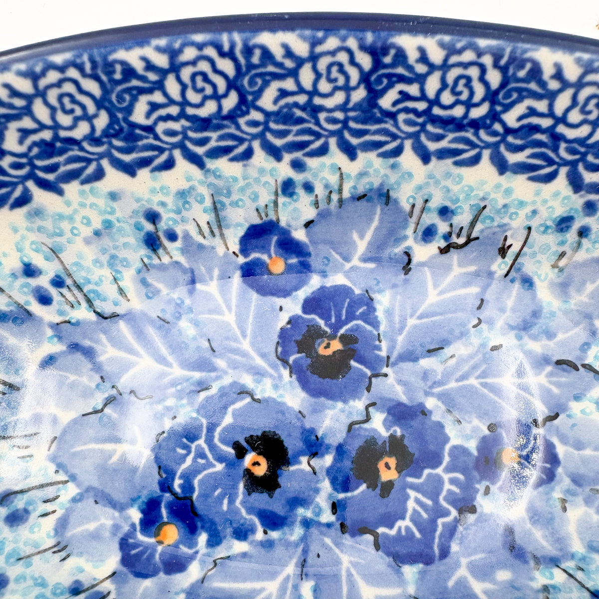 UNIKAT Deep Winter oval bowl, close-up rim detail showing dark blue rose border and pansy cluster