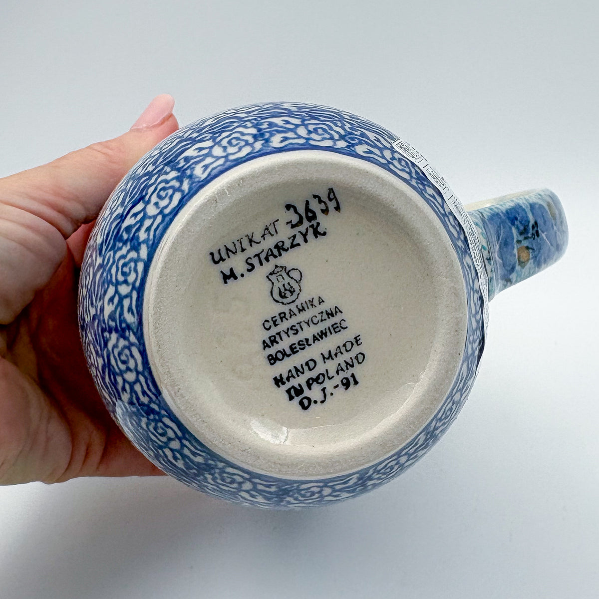 Bottom of Deep Winter latte mug showing Unikat stamp, alternate angle, held in hand