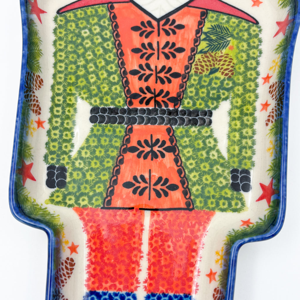 UNIKAT Green Nutcracker figural platter, close-up of uniform coat with belt detail and pinecone border