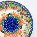 UNIKAT Hedgehog and Pumpkins plate, close-up rim view showing pumpkins, hedgehogs, acorns, and berries
