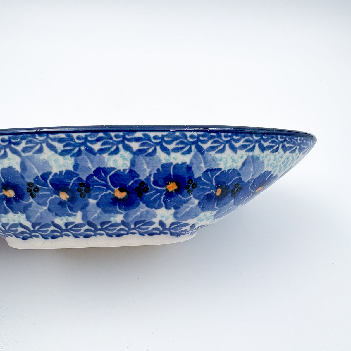 UNIKAT Deep Winter oval bowl, close-up exterior end view showing blue floral rim band