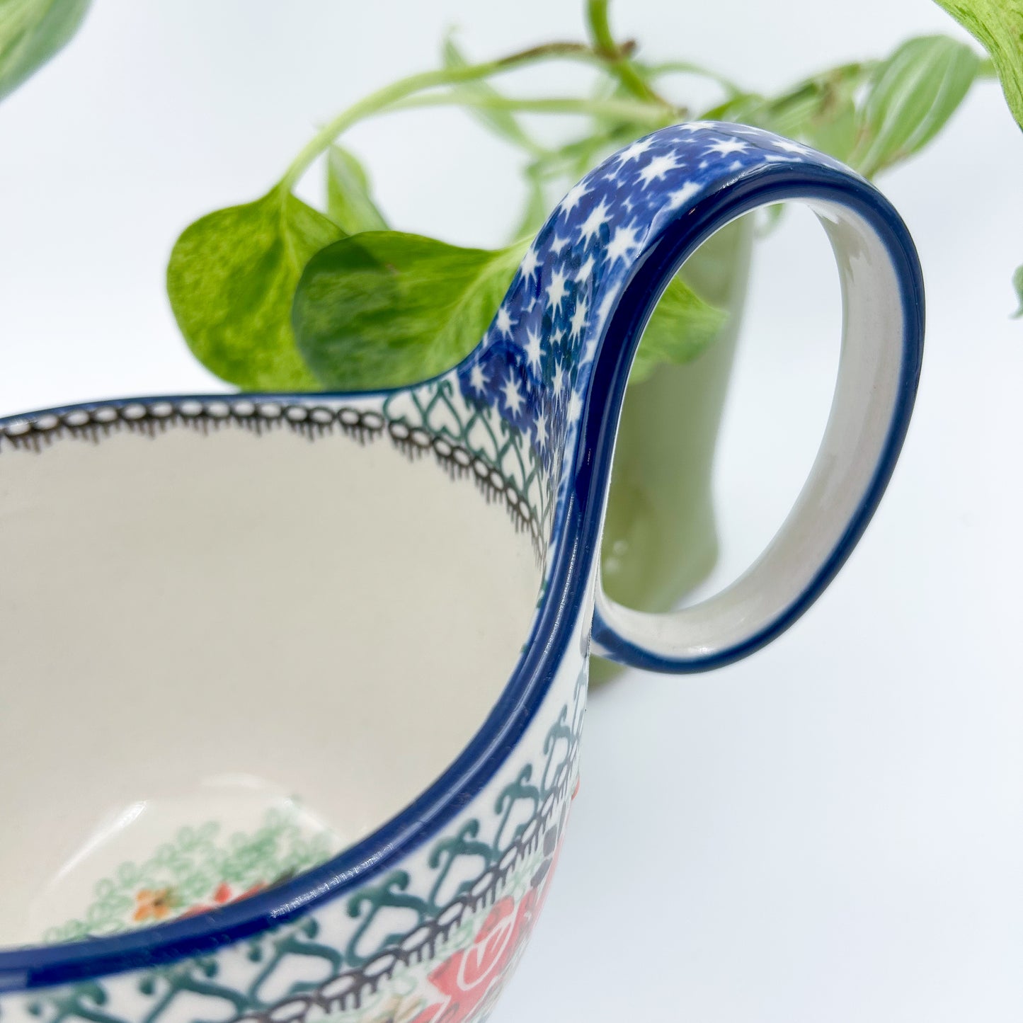 Polish pottery 16oz floral bowl with loop handle in the UNIKAT Sweet Leilani pattern. This Polish Pottery bowl is made by talented artisans from Poland.  16 oz of fluid.
6.26" x 4.49" x 5.51"
Ceramika Artystyczna Company