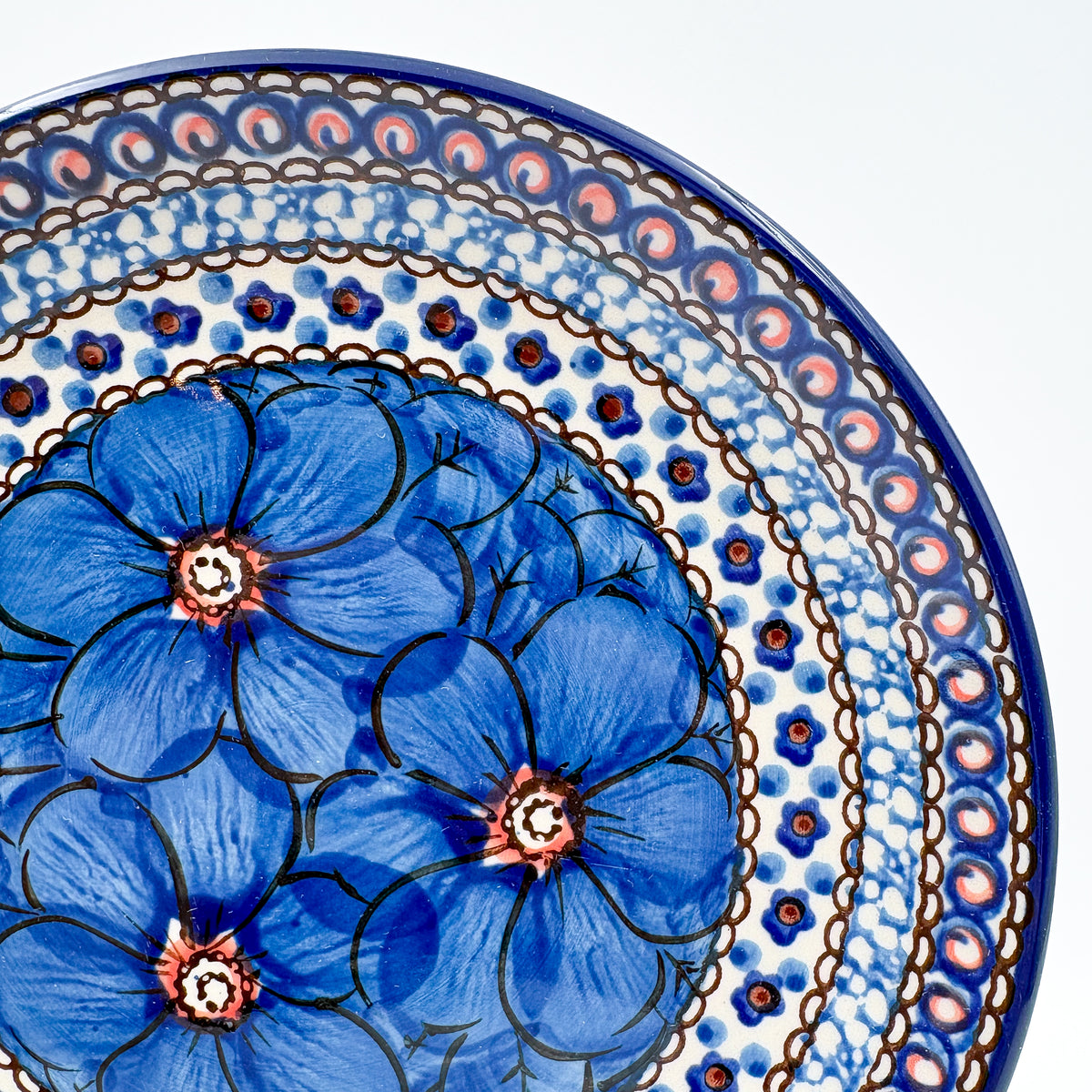 UNIKAT Cobalt Poppies dessert plate, close-up rim view showing blue poppy petals and scale border