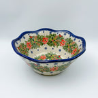 Christmas Cardinals wavy bowl, front view showing poinsettia, pinecone, and cardinal wreath pattern