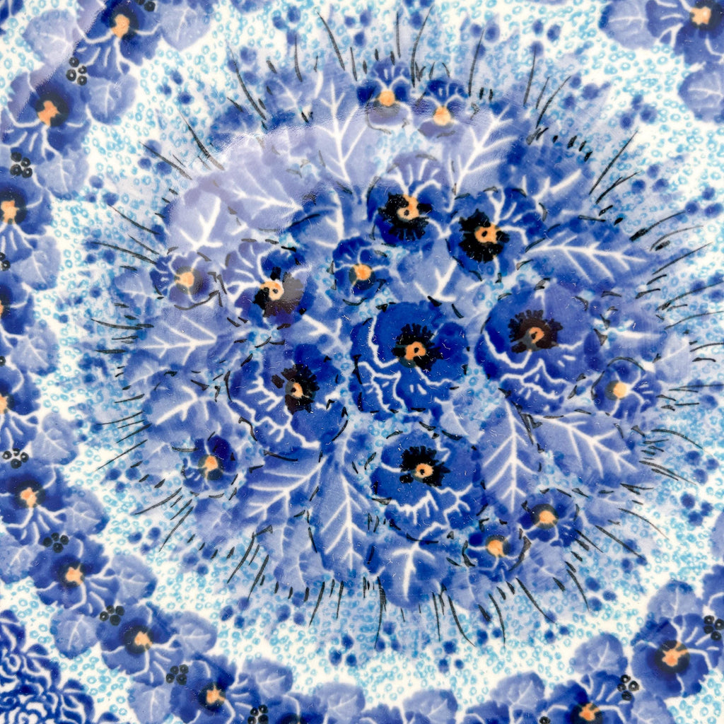 UNIKAT Deep Winter plate, close-up top-down view of blue pansy cluster center