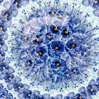 UNIKAT Deep Winter plate, close-up top-down view of blue pansy cluster center