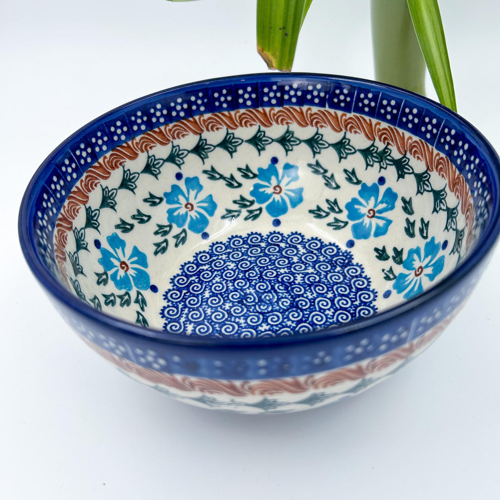 Blue Cornflower deep bowl, angled top-down view with plant in background
