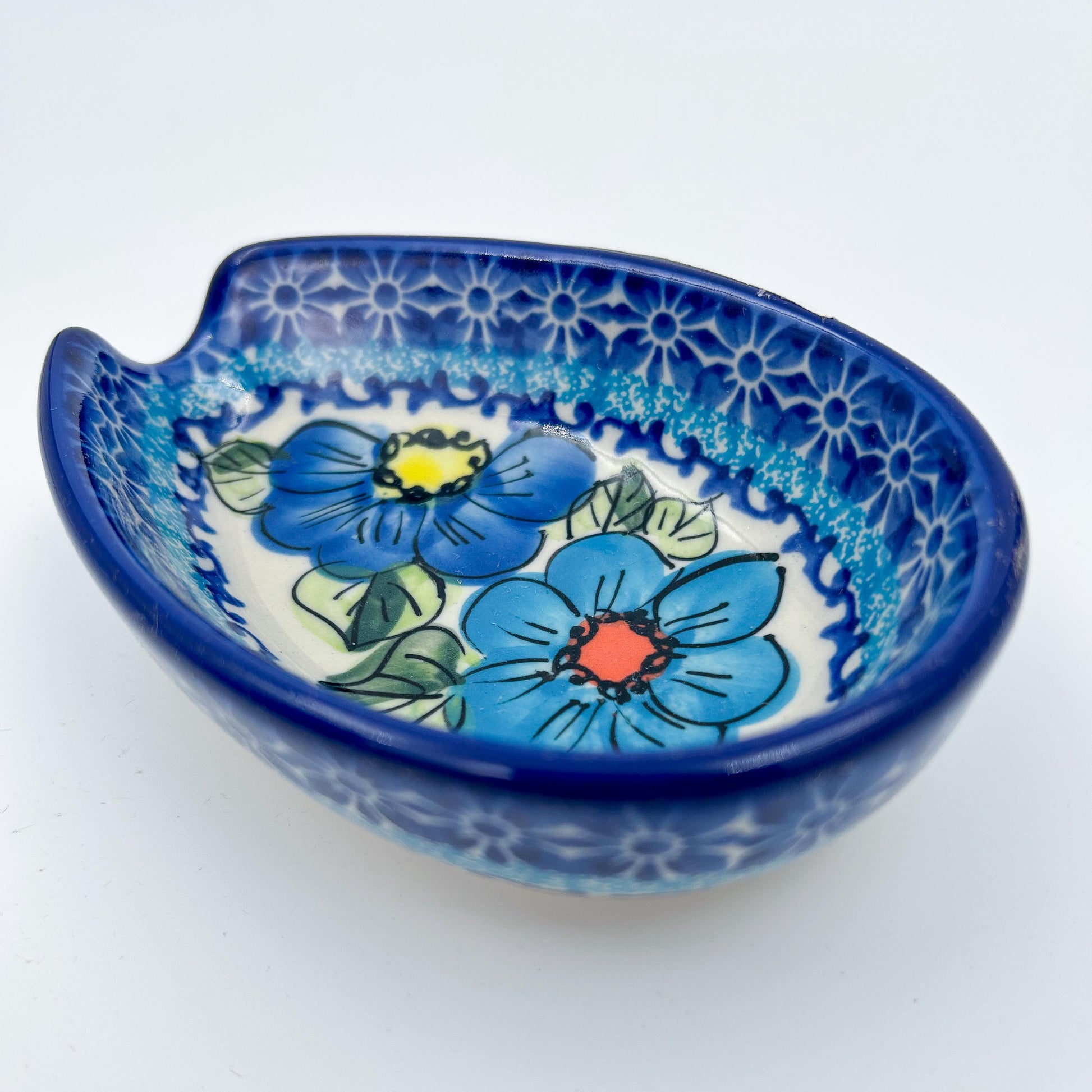 This 5” blue floral spoon rest is a handmade by talented Polish artisans. This is a Polish UNIKAT Bold Blue Poppies pattern 
Dimensions 5” x 3.54"
Ceramika BonaCompany