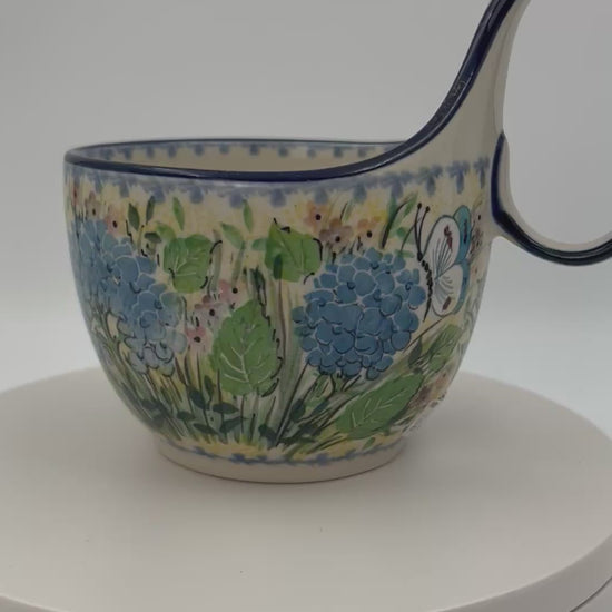 Polish pottery 16oz bowl with loop handle in the UNIKAT Blue Hydrangea pattern. This Polish Pottery bowl is made by talented artisans from Poland. 
6.26" x 4.49" x 5.51"
Ceramika Artystyczna Company