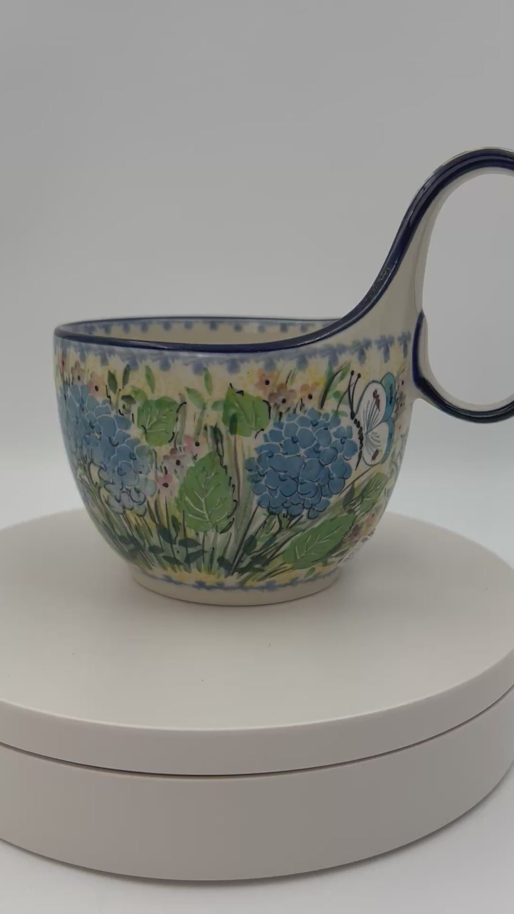 Polish pottery 16oz bowl with loop handle in the UNIKAT Blue Hydrangea pattern. This Polish Pottery bowl is made by talented artisans from Poland. 
6.26" x 4.49" x 5.51"
Ceramika Artystyczna Company