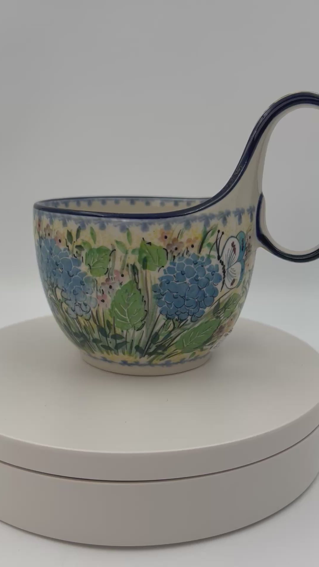 Polish pottery 16oz bowl with loop handle in the UNIKAT Blue Hydrangea pattern. This Polish Pottery bowl is made by talented artisans from Poland. 
6.26" x 4.49" x 5.51"
Ceramika Artystyczna Company